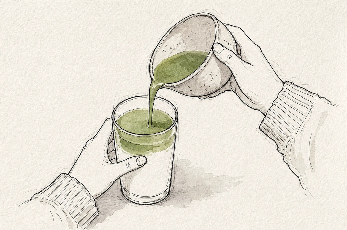 Matcha poured from the bowl over warm milk in a glass
