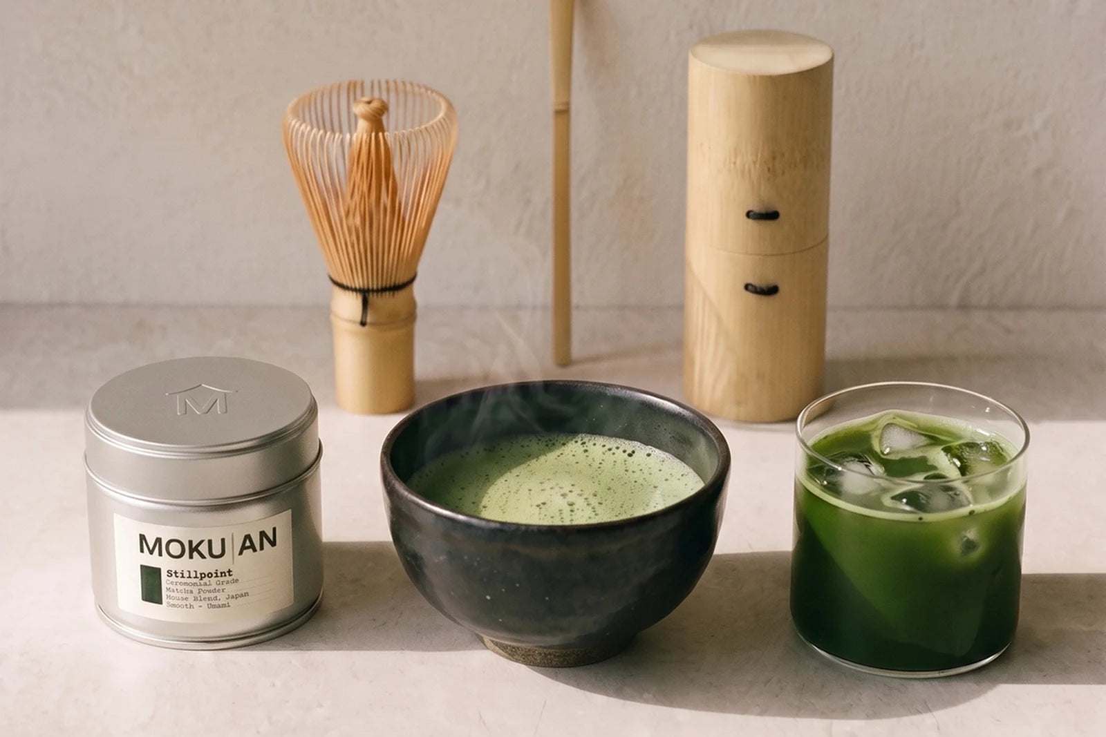 Eine Schale aufgeschlagener Matcha neben einem Glas Iced Matcha